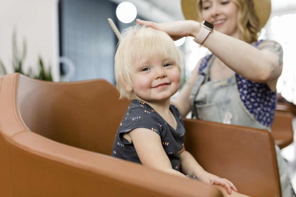 Menina criança loira cortando o cabelo